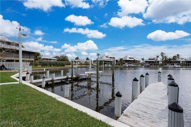 dock area with a lawn and a water view