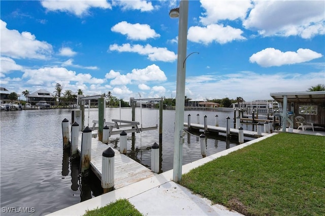 dock area with a yard and a water view