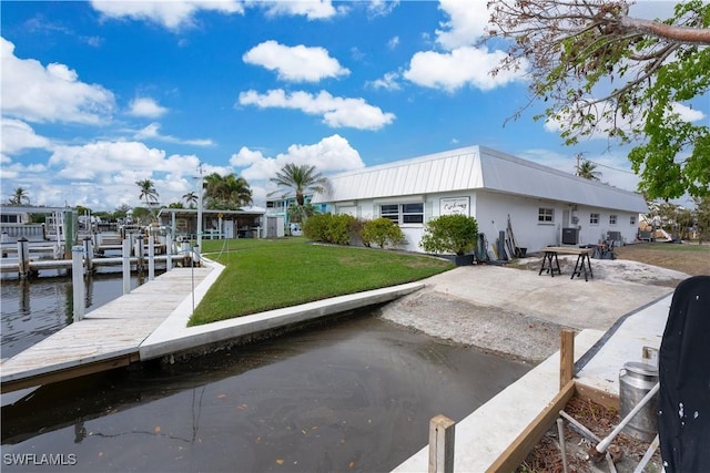 view of dock featuring a water view and a yard