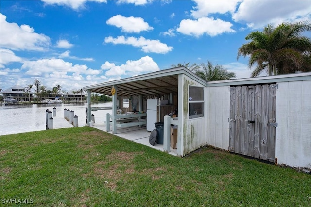 view of dock with a yard and a water view