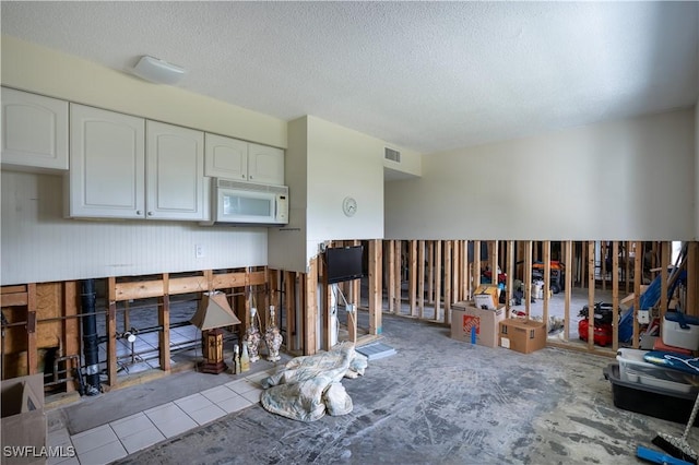 kitchen featuring white cabinets and a textured ceiling