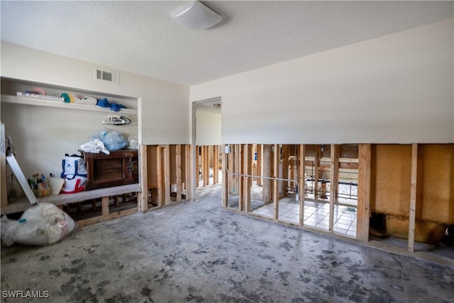 misc room featuring carpet floors and a textured ceiling