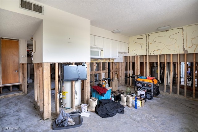 misc room with a textured ceiling, concrete floors, and water heater