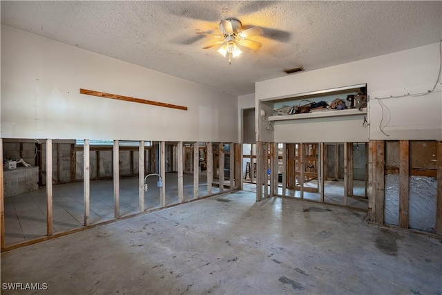 interior space with ceiling fan, concrete flooring, and a textured ceiling