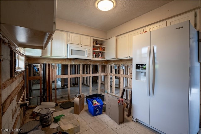 kitchen featuring white cabinets, white appliances, and a textured ceiling