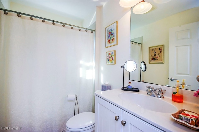 bathroom featuring vanity, toilet, and curtained shower