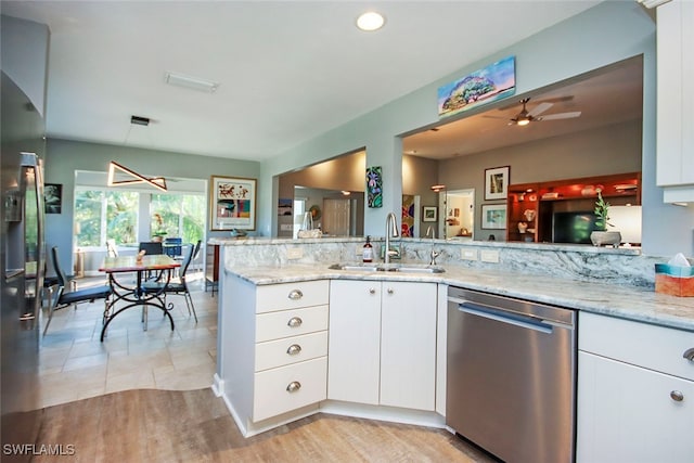 kitchen featuring sink, stainless steel dishwasher, light stone countertops, white cabinetry, and kitchen peninsula