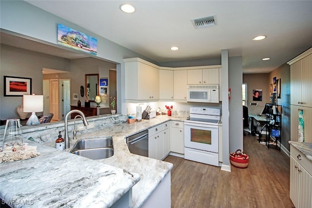 kitchen with dark hardwood / wood-style floors, sink, white appliances, and kitchen peninsula