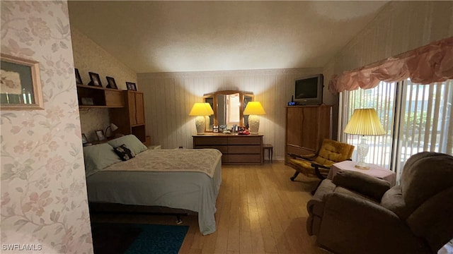 bedroom with light hardwood / wood-style floors and vaulted ceiling