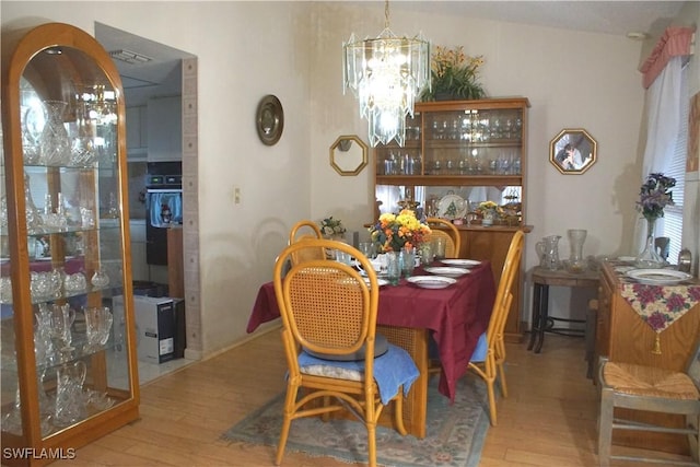 dining room featuring hardwood / wood-style floors and an inviting chandelier