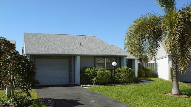 single story home featuring a garage and a front lawn