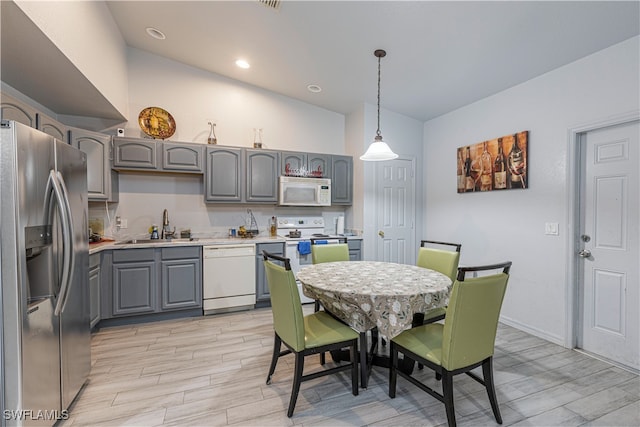 kitchen featuring pendant lighting, white appliances, sink, gray cabinets, and light hardwood / wood-style floors