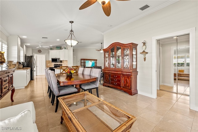 dining space with light tile patterned floors, ornamental molding, and a wealth of natural light