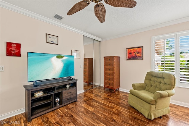 living area with crown molding, a textured ceiling, and dark wood-type flooring