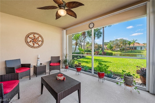 sunroom with a water view and ceiling fan