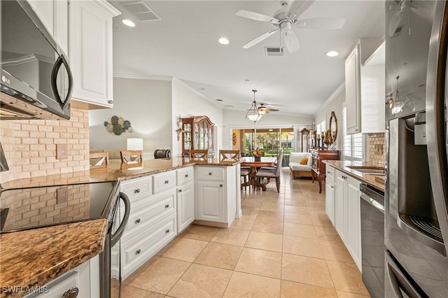 kitchen with kitchen peninsula, white cabinets, light tile patterned flooring, and appliances with stainless steel finishes