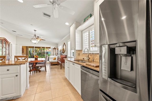 kitchen with sink, white cabinets, vaulted ceiling, and appliances with stainless steel finishes