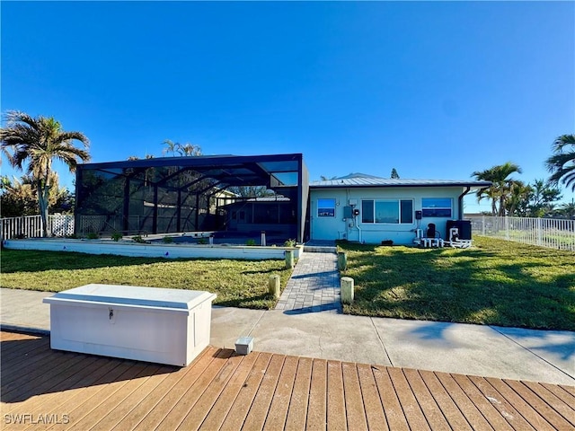 wooden terrace featuring a yard and a lanai