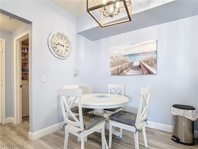 dining room with hardwood / wood-style flooring, a notable chandelier, and washer / clothes dryer