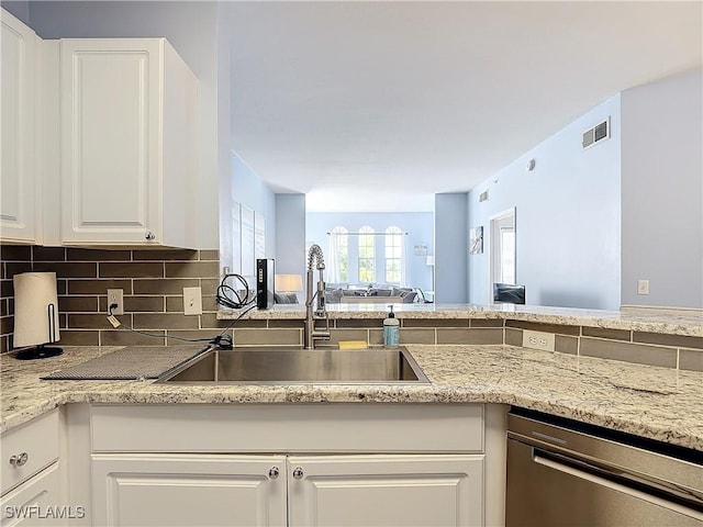 kitchen with white cabinets, dishwasher, sink, and tasteful backsplash