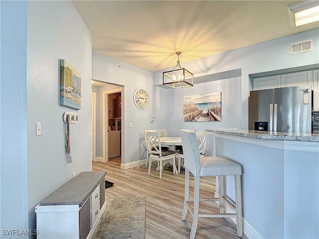 dining area featuring a notable chandelier and light wood-type flooring