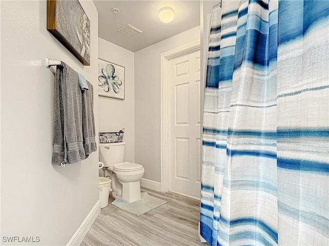 bathroom with hardwood / wood-style flooring and toilet