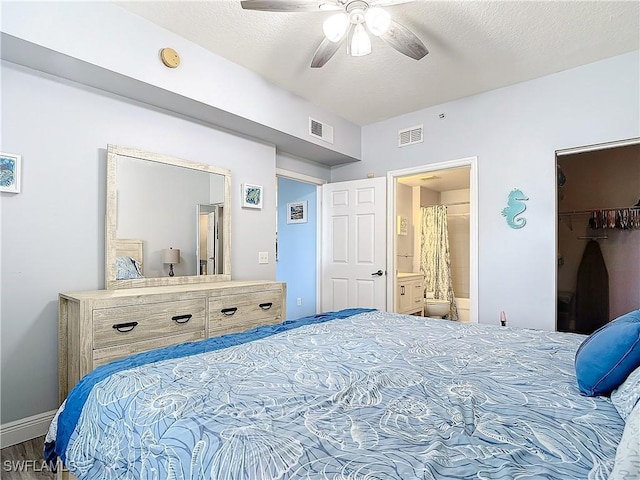 bedroom with a walk in closet, ensuite bath, ceiling fan, a textured ceiling, and a closet