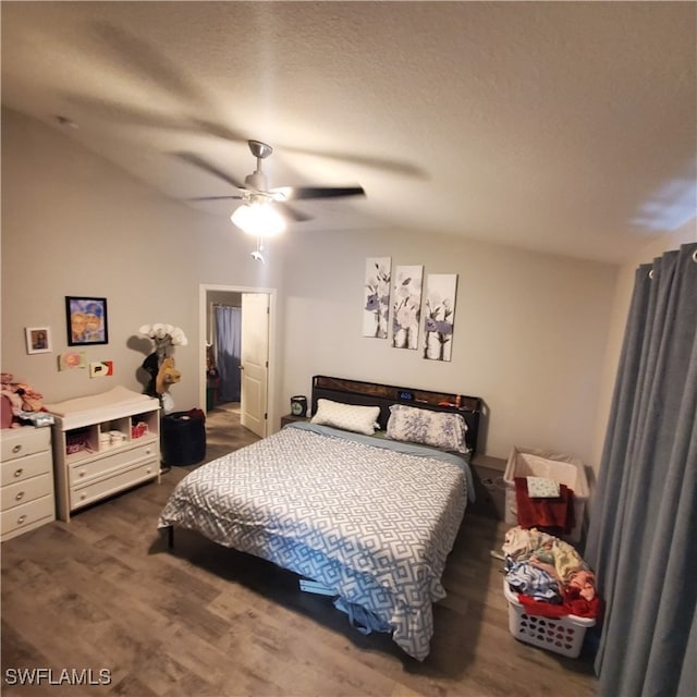 bedroom featuring a textured ceiling, lofted ceiling, ceiling fan, and dark wood-type flooring