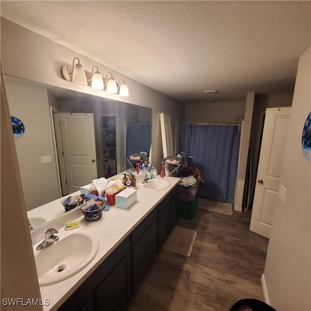 bathroom with vanity, wood-type flooring, and a textured ceiling