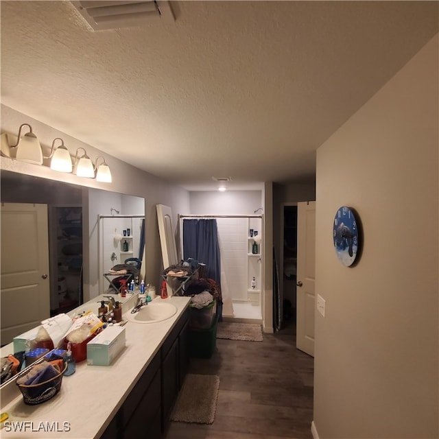 bathroom featuring vanity, wood-type flooring, and a textured ceiling