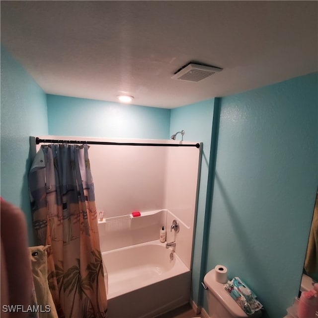 bathroom featuring toilet and shower / bath combo with shower curtain