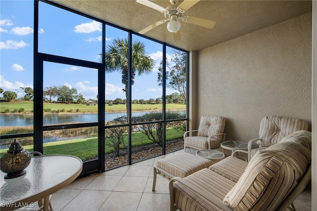 sunroom / solarium with ceiling fan, a healthy amount of sunlight, and a water view