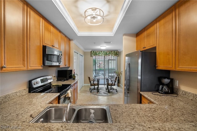 kitchen featuring light stone countertops, sink, stainless steel appliances, a raised ceiling, and ornamental molding