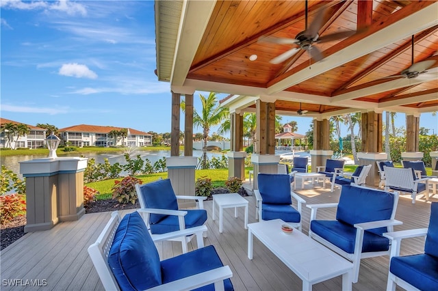 wooden terrace featuring a gazebo, ceiling fan, a water view, and an outdoor living space