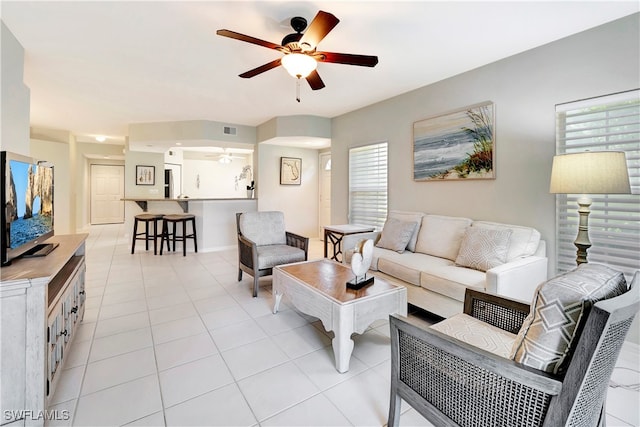 living room with ceiling fan, light tile patterned flooring, and a healthy amount of sunlight