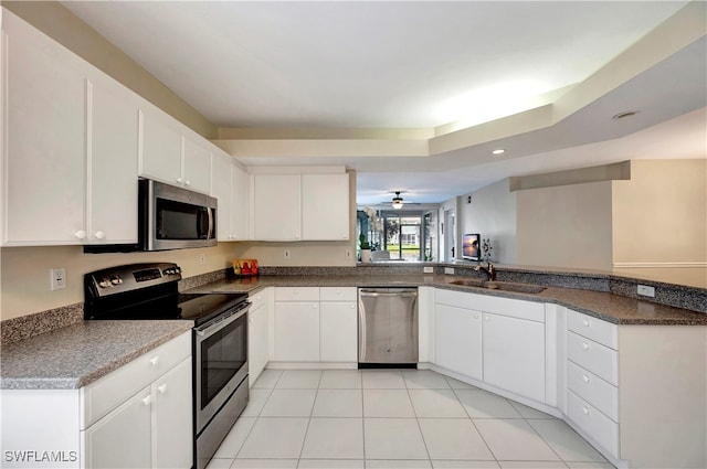 kitchen with sink, ceiling fan, light tile patterned flooring, white cabinetry, and stainless steel appliances