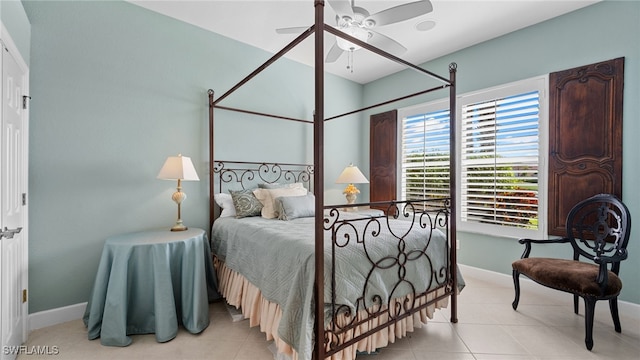 bedroom featuring light tile patterned flooring, a ceiling fan, and baseboards