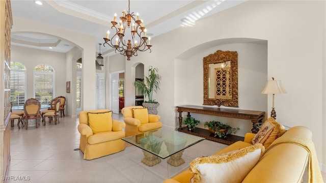 interior space featuring a raised ceiling, arched walkways, an inviting chandelier, and ornamental molding