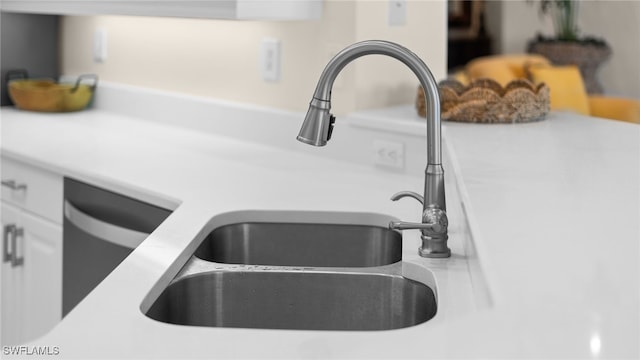 details featuring dishwasher, light countertops, white cabinets, and a sink