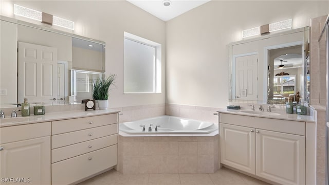 full bathroom with a garden tub, two vanities, a stall shower, tile patterned floors, and a sink