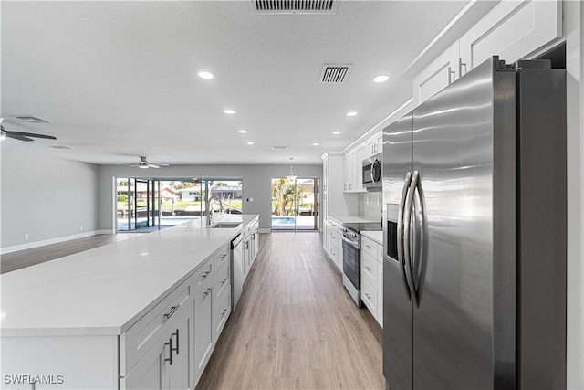 kitchen with white cabinets, appliances with stainless steel finishes, and sink