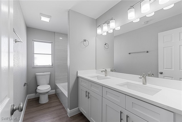 full bathroom with vanity, hardwood / wood-style flooring, toilet, and shower / bathtub combination