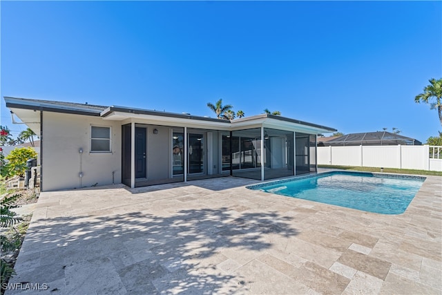 view of swimming pool with a sunroom and a patio area