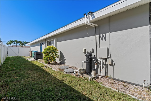 view of side of property with a yard and central air condition unit