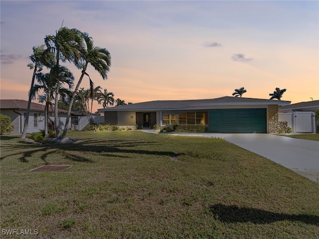 ranch-style house featuring a yard and a garage