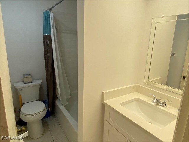 full bathroom with tile patterned floors, vanity, toilet, and shower / bath combo with shower curtain