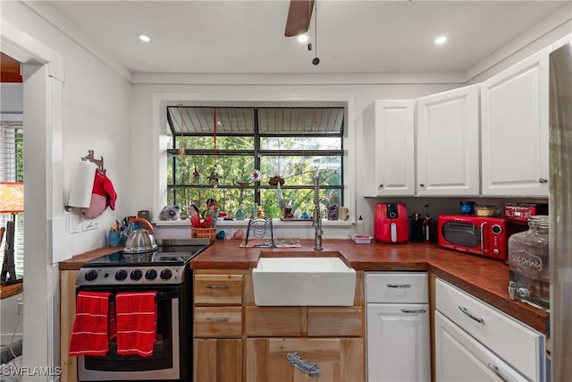 kitchen featuring white cabinetry, sink, electric range, and a healthy amount of sunlight