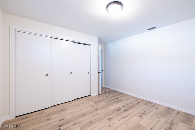 unfurnished bedroom with light hardwood / wood-style floors and a closet