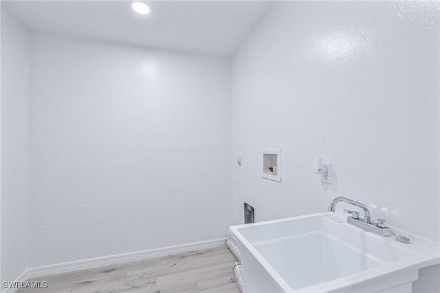 washroom featuring hookup for a washing machine, sink, and light hardwood / wood-style floors