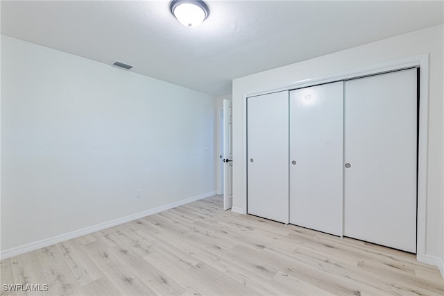 unfurnished bedroom with a closet and light hardwood / wood-style flooring